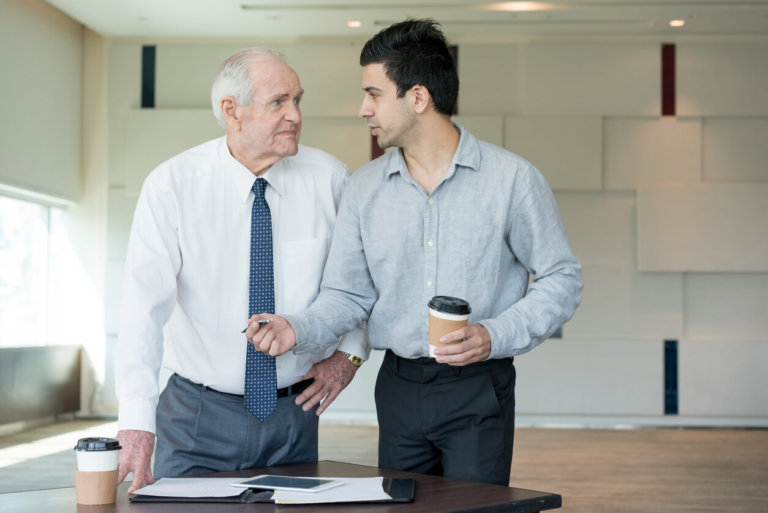 older man speaking with young employer
