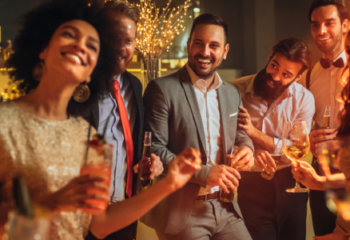 group of men and women at a bar holding wine, beer, and cocktails holiday party sexual harassment