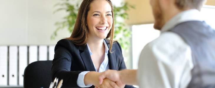 business woman shaking hands with a business man during an employment interview