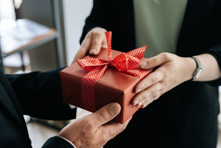Woman giving gift to man