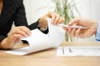 Woman tears agreement documents in front of agent who wants to get a signature