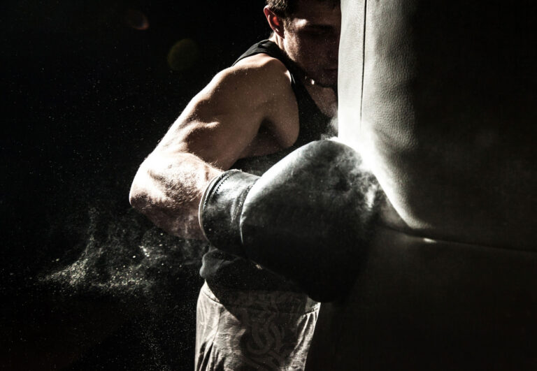 A boxer landing a right hook on a punching bag