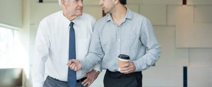 older man speaking with young employer