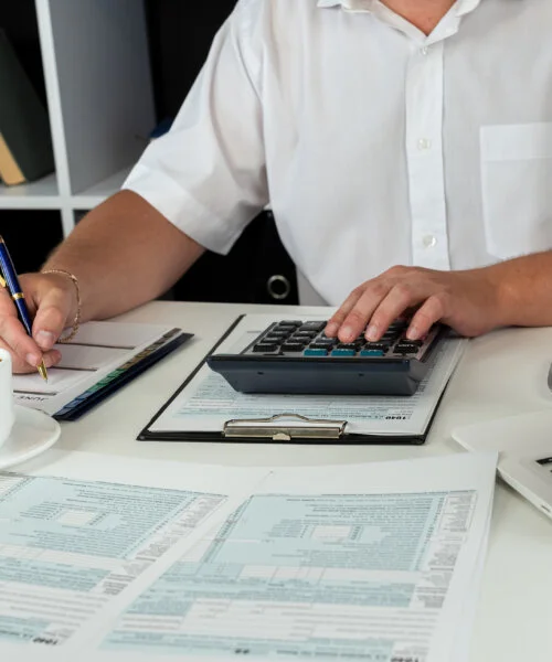 man hand using calculator for accounting individual income 1040 tax form. April season to pay tax