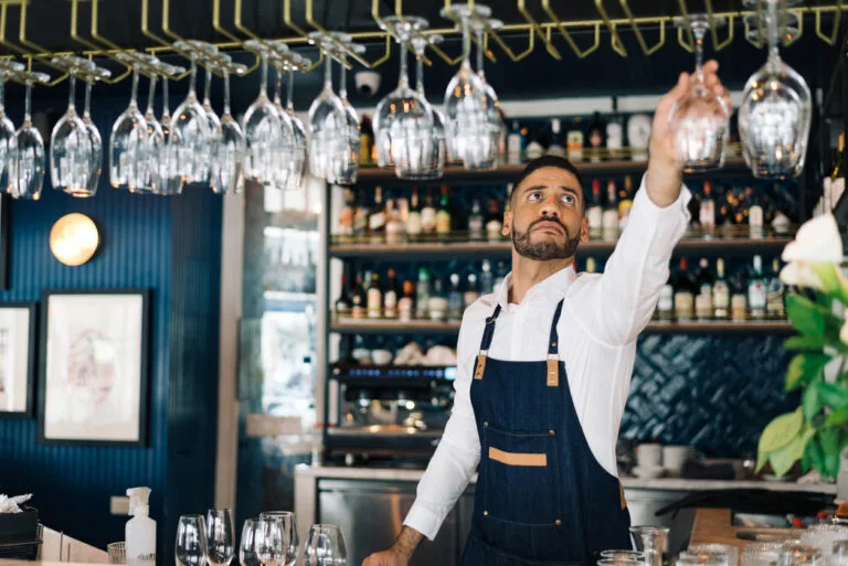 Bartender hanging wine glasses