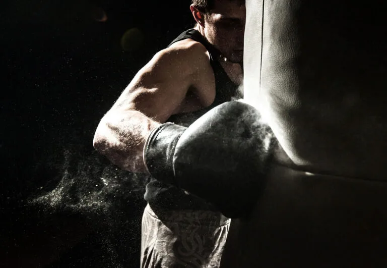 A boxer landing a right hook on a punching bag